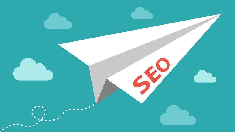 Green SEO paper airplane in flight with cartoon clouds in the background.